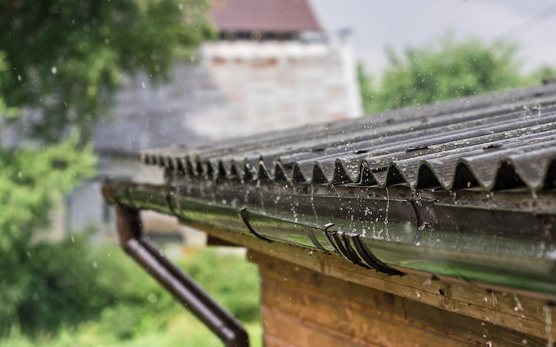 Streams of rain are flowing down from the roof